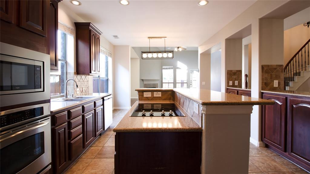 8698 Fisher Road Frisco, TX 75033 - Photo 9 of 33 a kitchen with stainless steel appliances granite countertop a stove and a sink