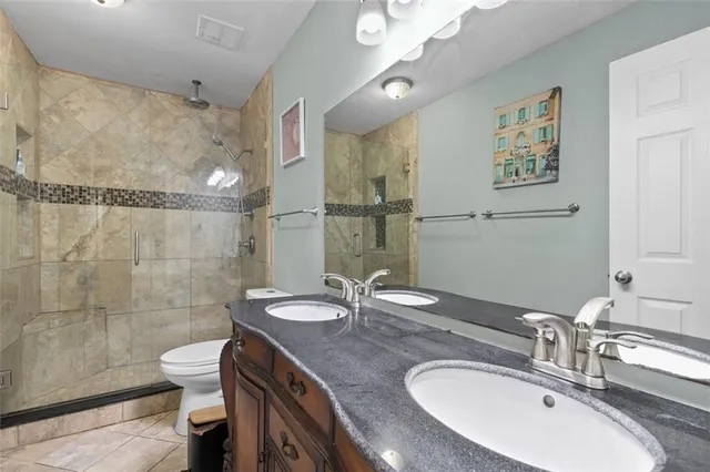 a bathroom with a sink a toilet and shower