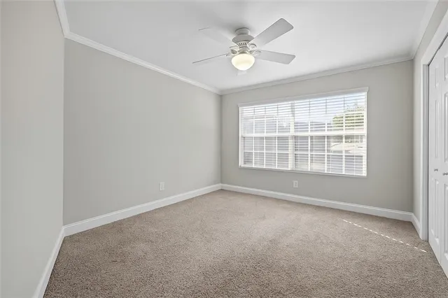an empty room with windows and fan