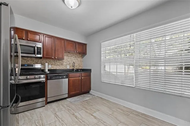 a kitchen with stainless steel appliances granite countertop a stove a sink and a microwave