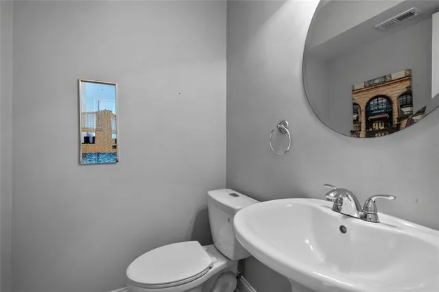 a bathroom with a toilet a sink and mirror