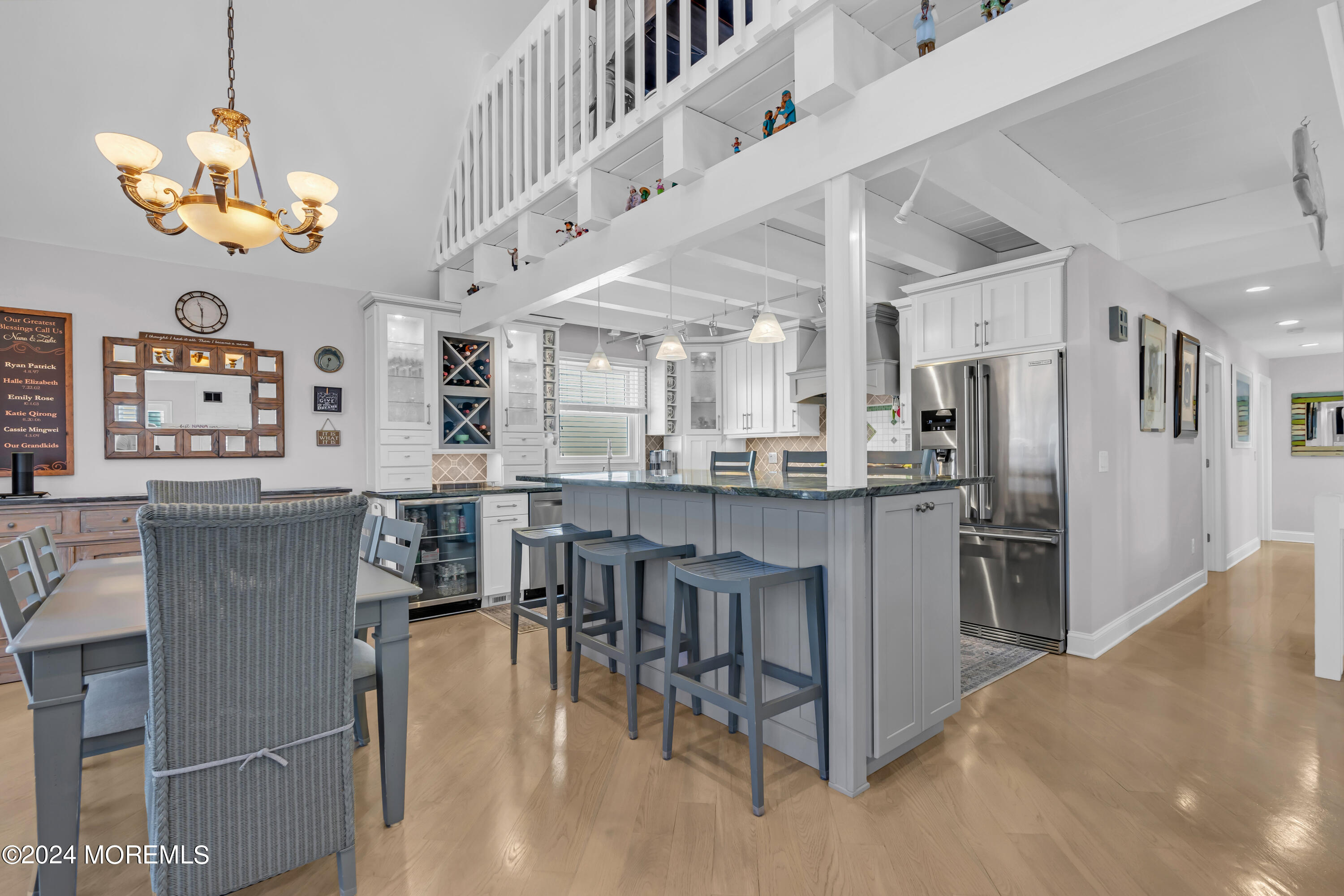 381 Aldo Drive Toms River, NJ 08753 - Photo 12 of 58 a kitchen with stainless steel appliances kitchen island granite countertop a refrigerator a stove top oven a dining table and chairs with wooden floor