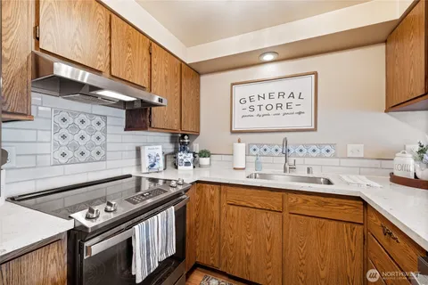a kitchen with stainless steel appliances a sink stove and cabinets
