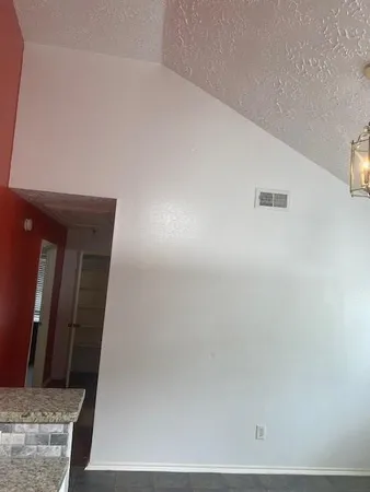 a kitchen with granite countertop a sink a white cabinets and a window