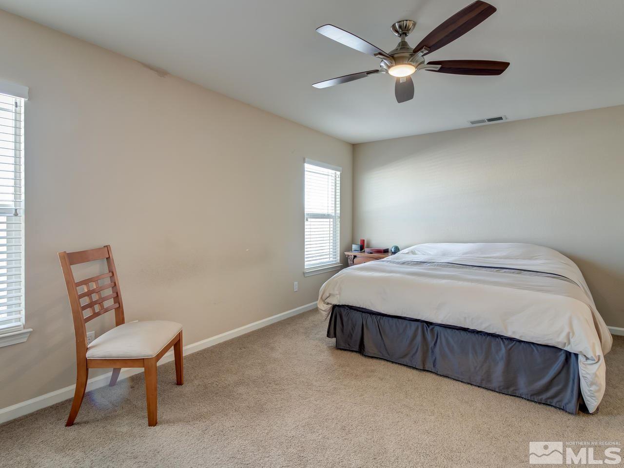9055 Convair Way Reno, NV 89506 - Photo 17 of 24 a bedroom with a bed a chair and a chandelier