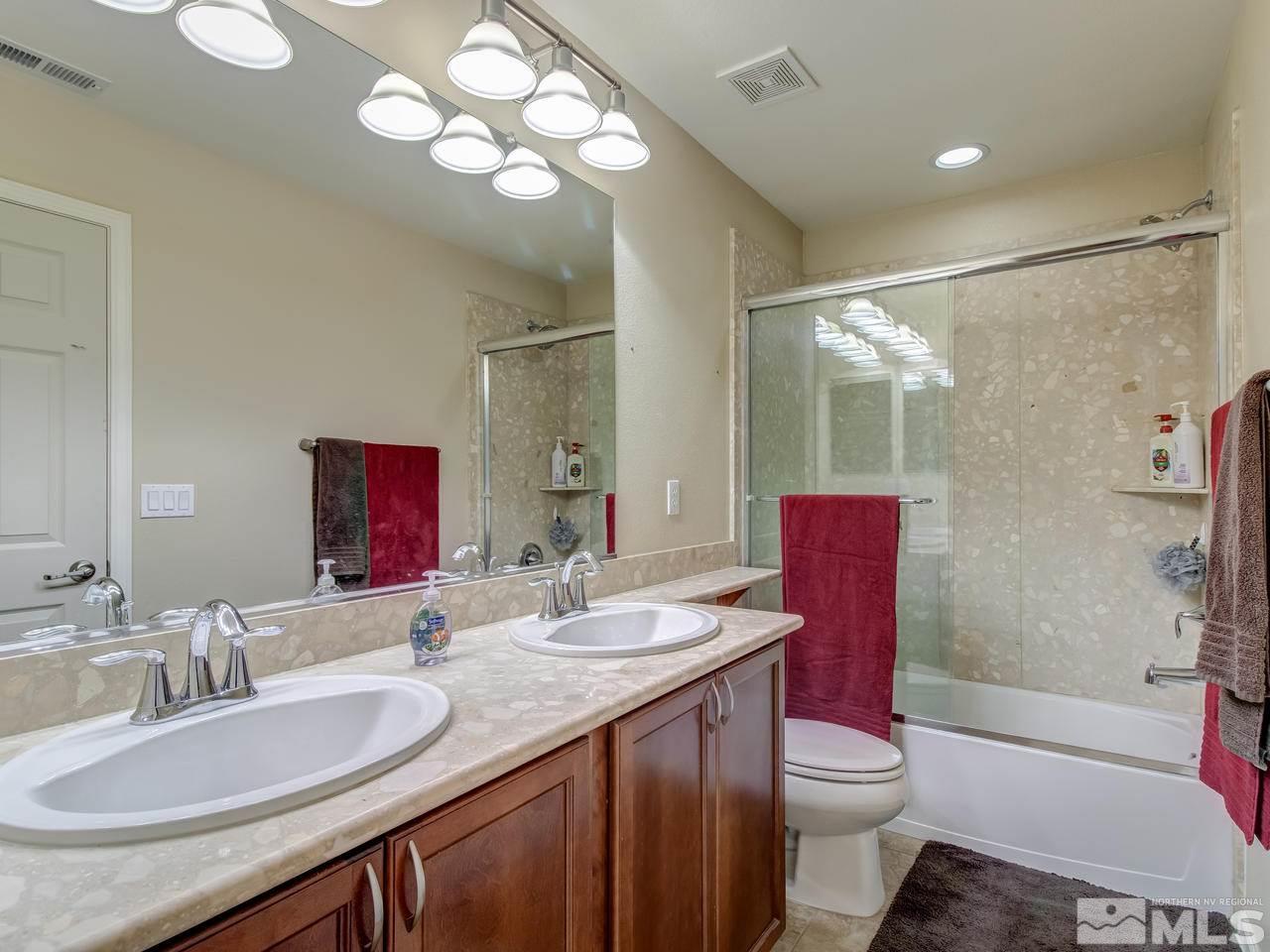 9055 Convair Way Reno, NV 89506 - Photo 21 of 24 a bathroom with a granite countertop toilet sink and a mirror