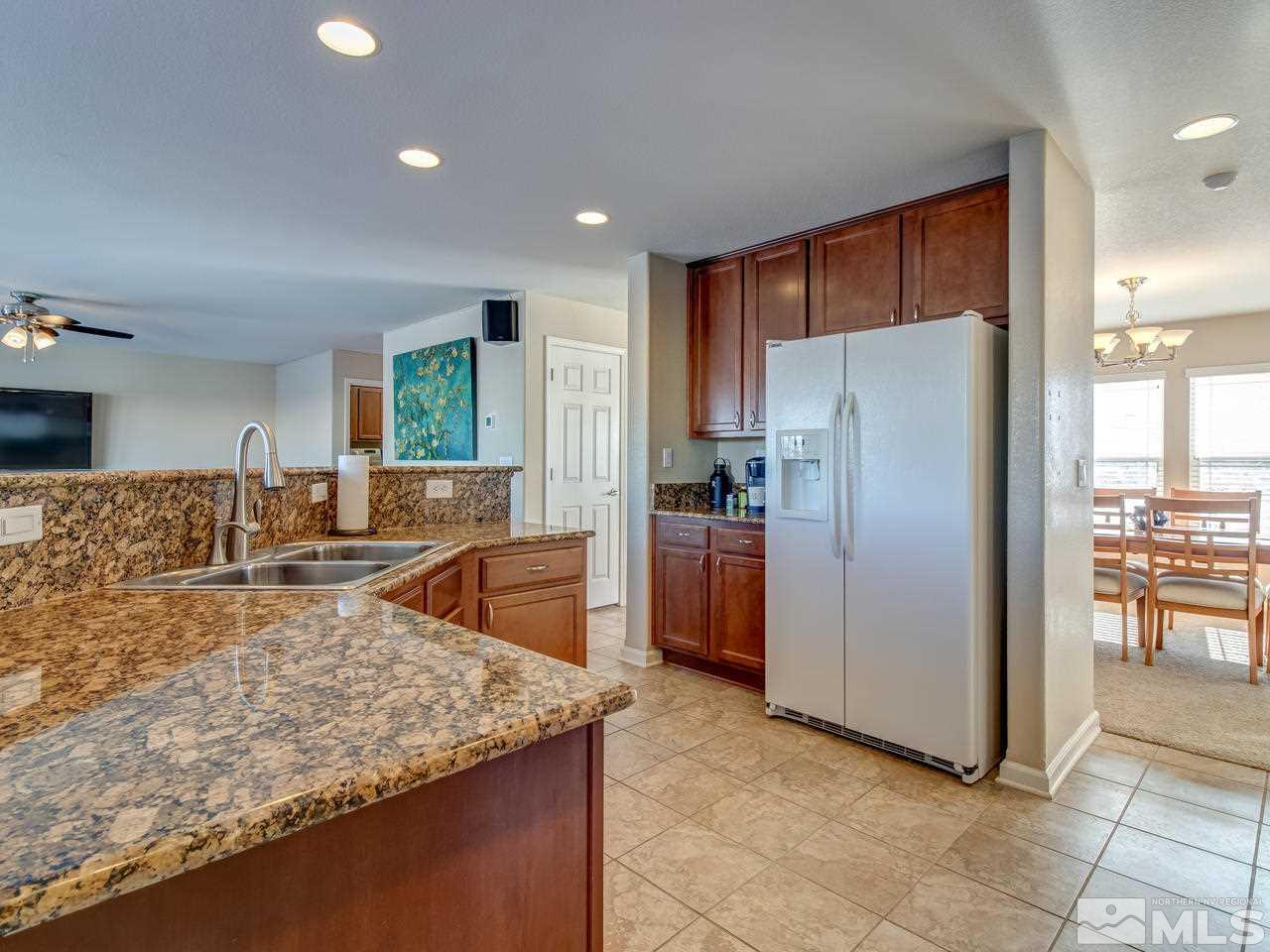9055 Convair Way Reno, NV 89506 - Photo 3 of 24 a kitchen with stainless steel appliances granite countertop a refrigerator a stove and a sink