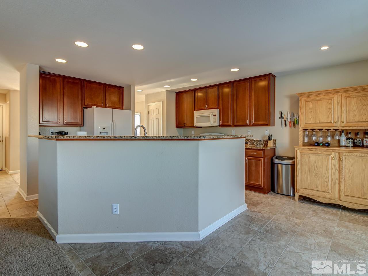 9055 Convair Way Reno, NV 89506 - Photo 4 of 24 a kitchen with stainless steel appliances granite countertop a refrigerator sink and cabinets