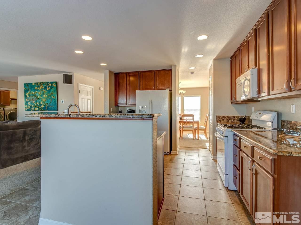 9055 Convair Way Reno, NV 89506 - Photo 5 of 24 a kitchen with stainless steel appliances granite countertop a stove a sink a refrigerator and a oven