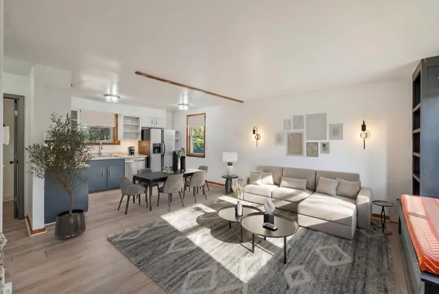 a living room with lots of furniture and view of kitchen