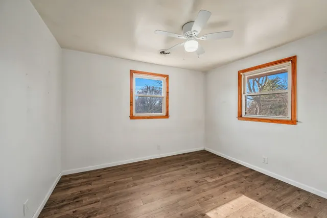 a view of empty room with wooden floor