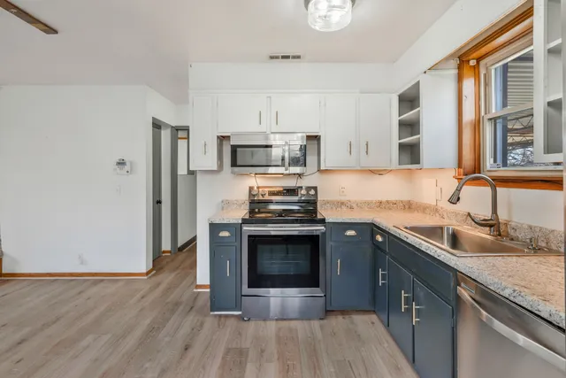 a kitchen with granite countertop a sink stove and refrigerator