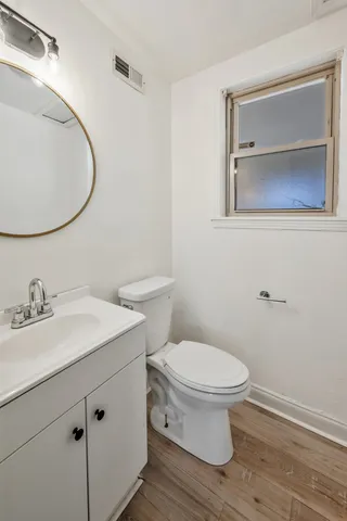 a bathroom with a toilet a sink and mirror