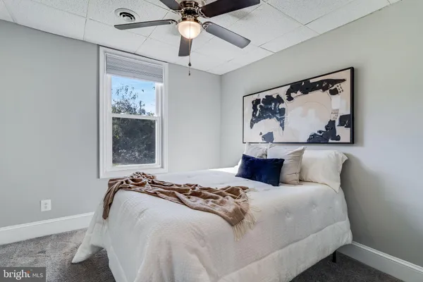 a bedroom with a bed and a painting on the wall