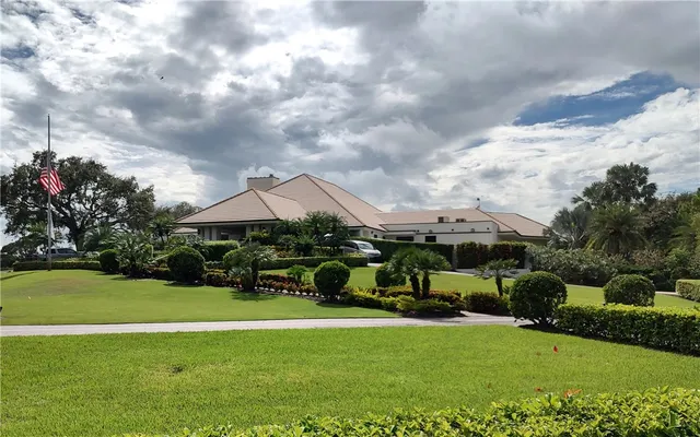 a view of a house with garden and a trees