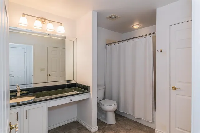 a bathroom with a sink a toilet and a mirror