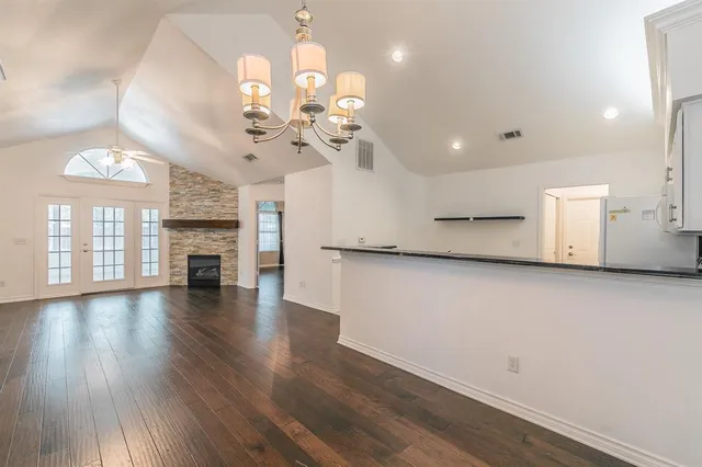 a view of a room with wooden floor and chandelier