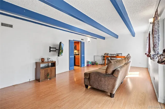 a living room with furniture and a wooden floor