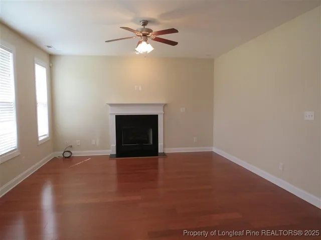 an empty room with windows and fireplace