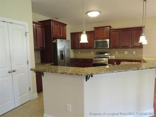 a kitchen with stainless steel appliances granite countertop a sink refrigerator and microwave