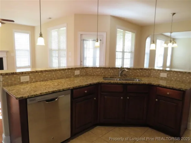 a kitchen with granite countertop a sink and a wooden cabinets