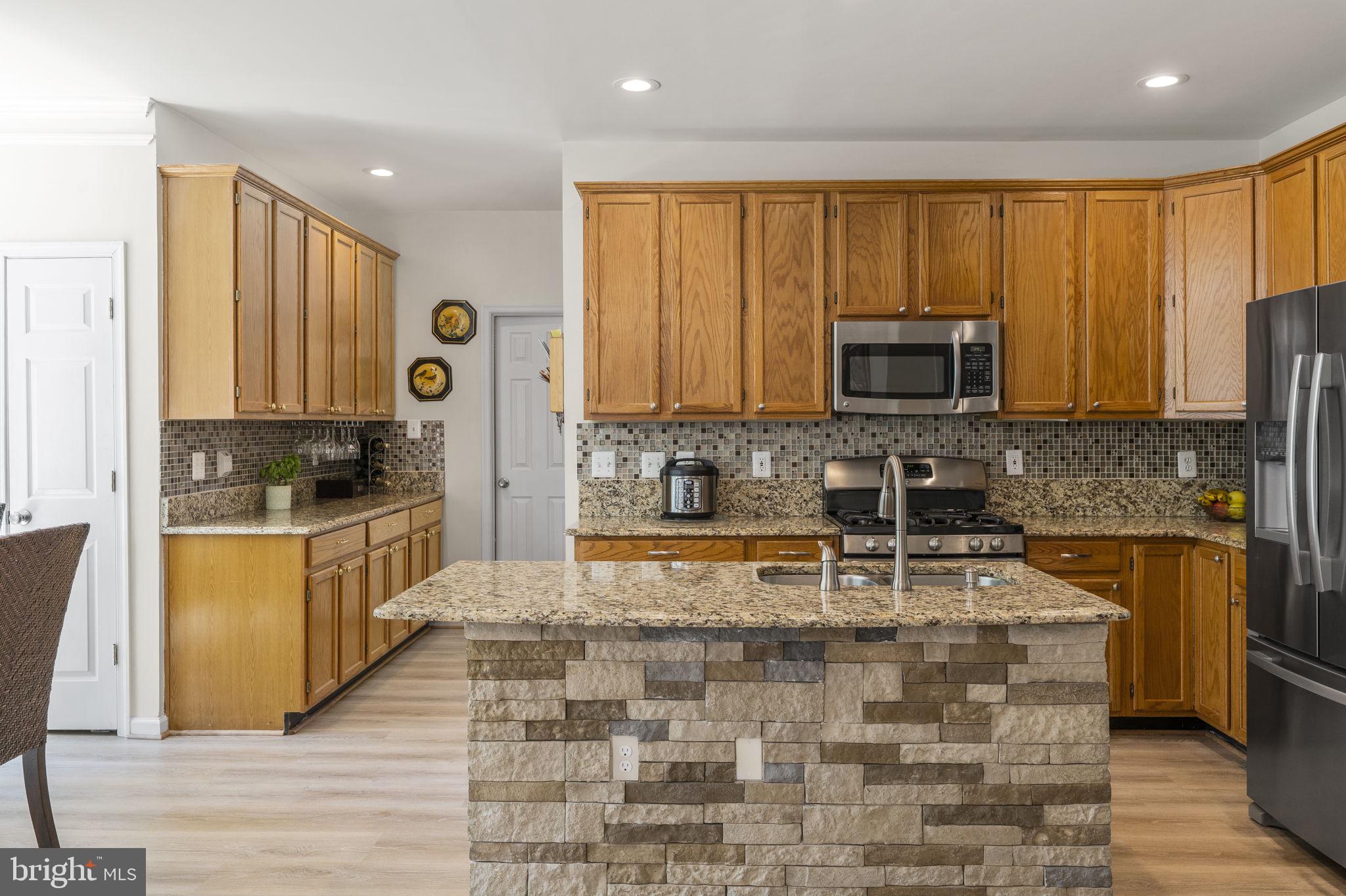 2408 Ripplemeade Court Herndon, VA 20171 - Photo 6 of 36 a large kitchen with stainless steel appliances granite countertop a stove a sink a microwave and a refrigerator