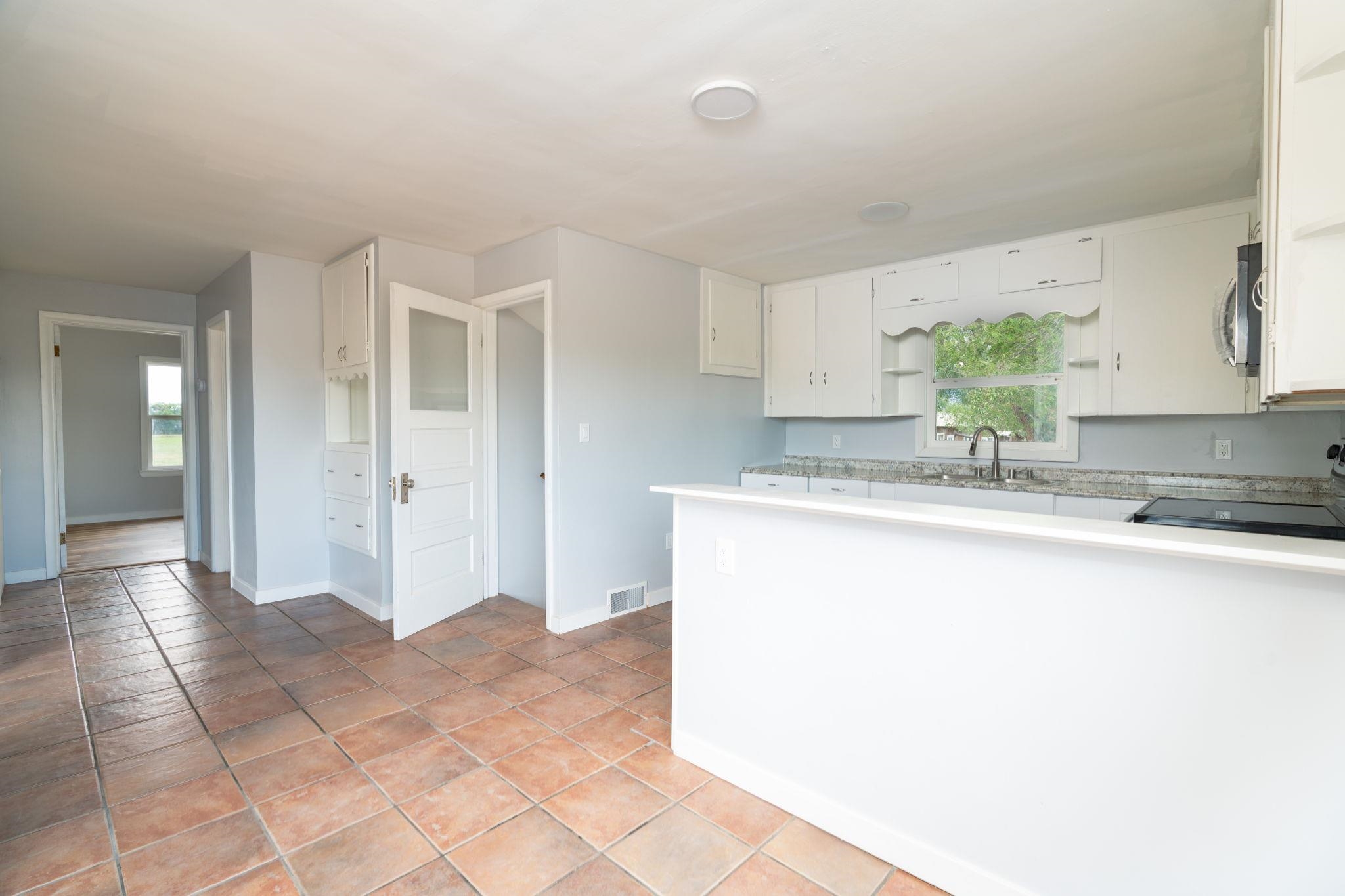 6038 Townsend Road Delta, CO 81416 - Photo 22 of 42 a kitchen with granite countertop a sink and a stove top oven