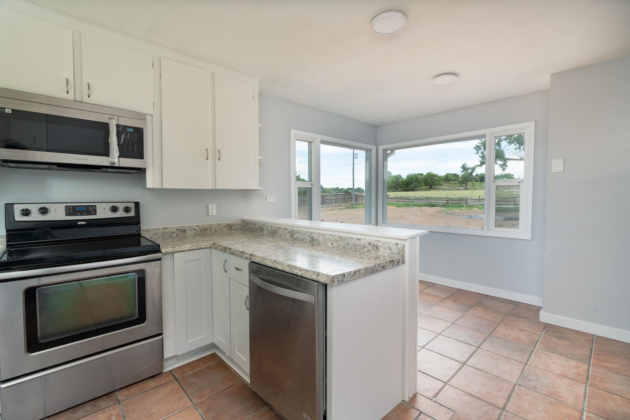 6038 Townsend Road Delta, CO 81416 - Photo 24 of 42 a kitchen with stainless steel appliances granite countertop a stove and a microwave