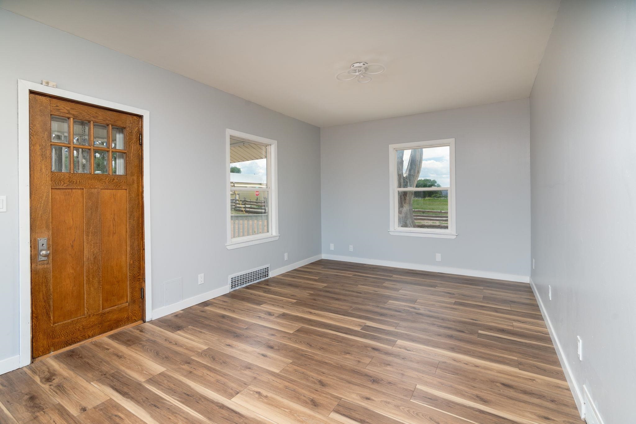 6038 Townsend Road Delta, CO 81416 - Photo 6 of 42 a view of an empty room with wooden floor and a window