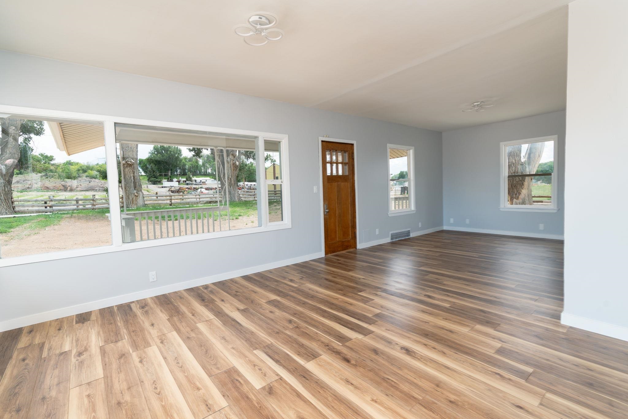 6038 Townsend Road Delta, CO 81416 - Photo 8 of 42 a view of an empty room with wooden floor and a window