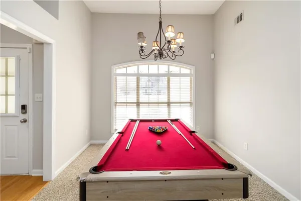 a room with pool table and windows