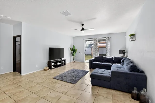 a living room with furniture and a flat screen tv with kitchen view