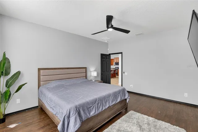 a bathroom with a granite countertop sink a toilet a mirror and shower