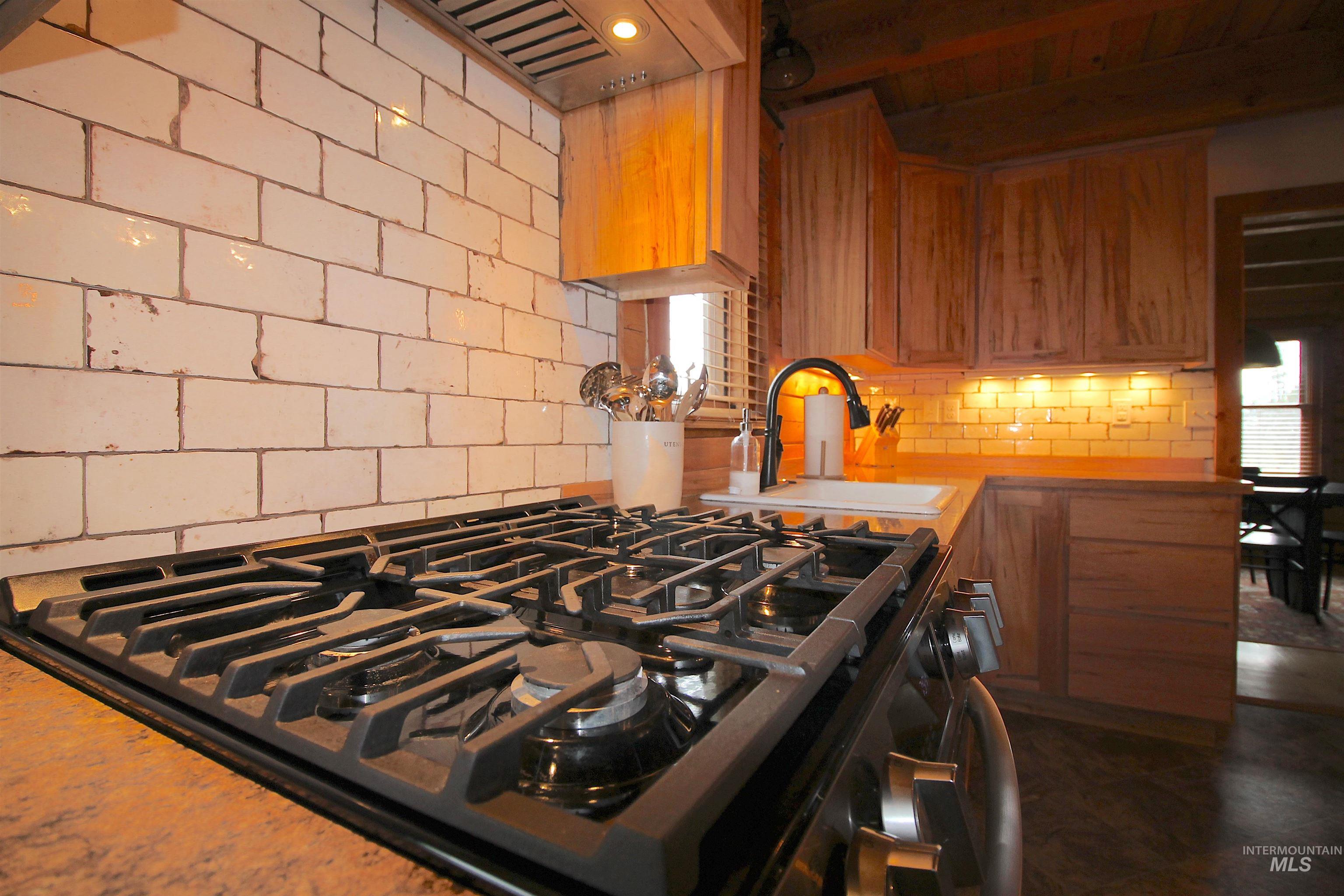 2609 Highway 95 Council, ID 83612 - Photo 18 of 49 Kitchen featuring gas stove, light countertops, tasteful backsplash, and wood finish cabinets