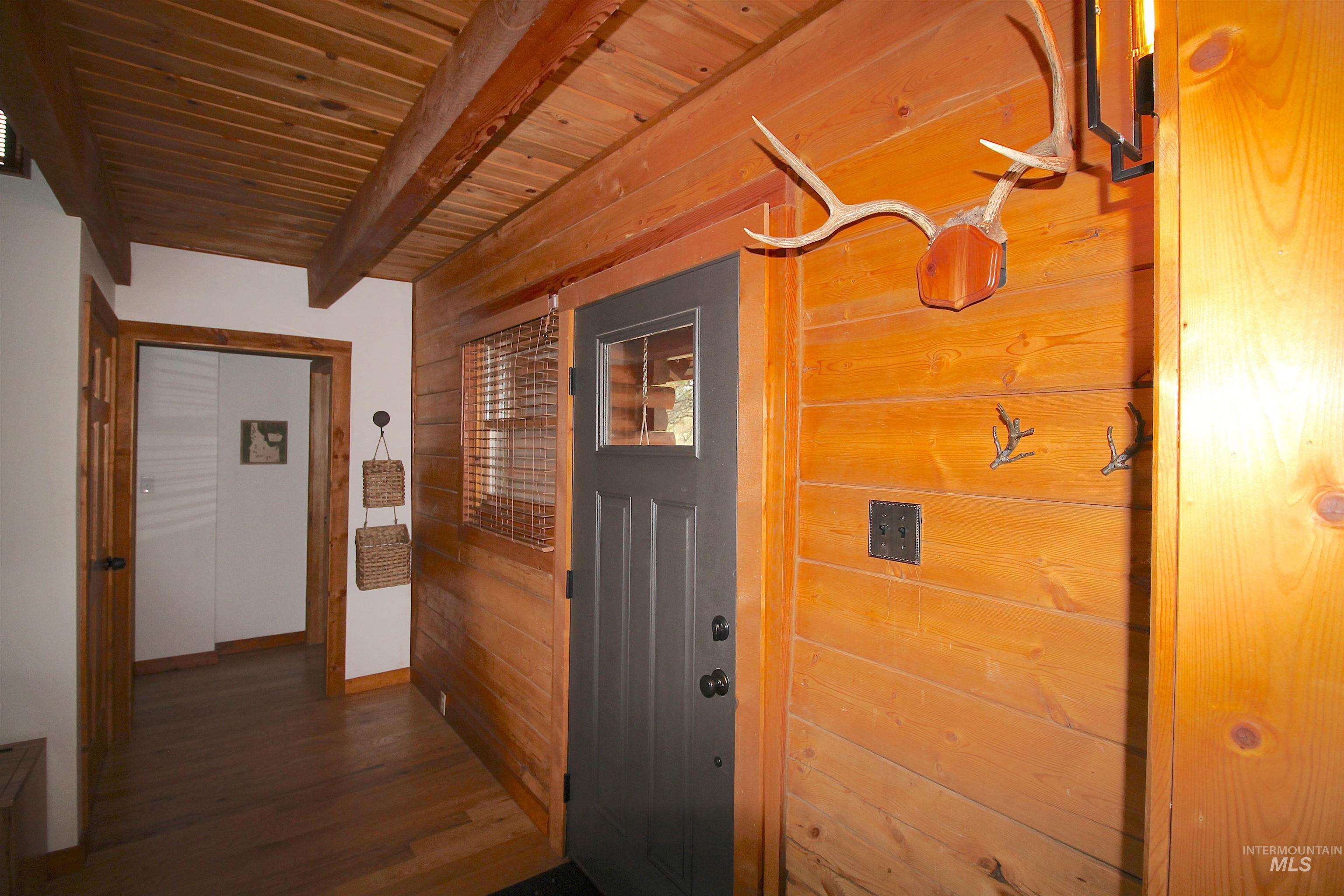 2609 Highway 95 Council, ID 83612 - Photo 21 of 49 Hallway featuring wooden walls, a wooden ceiling with exposed beams, and dark wood finished floors