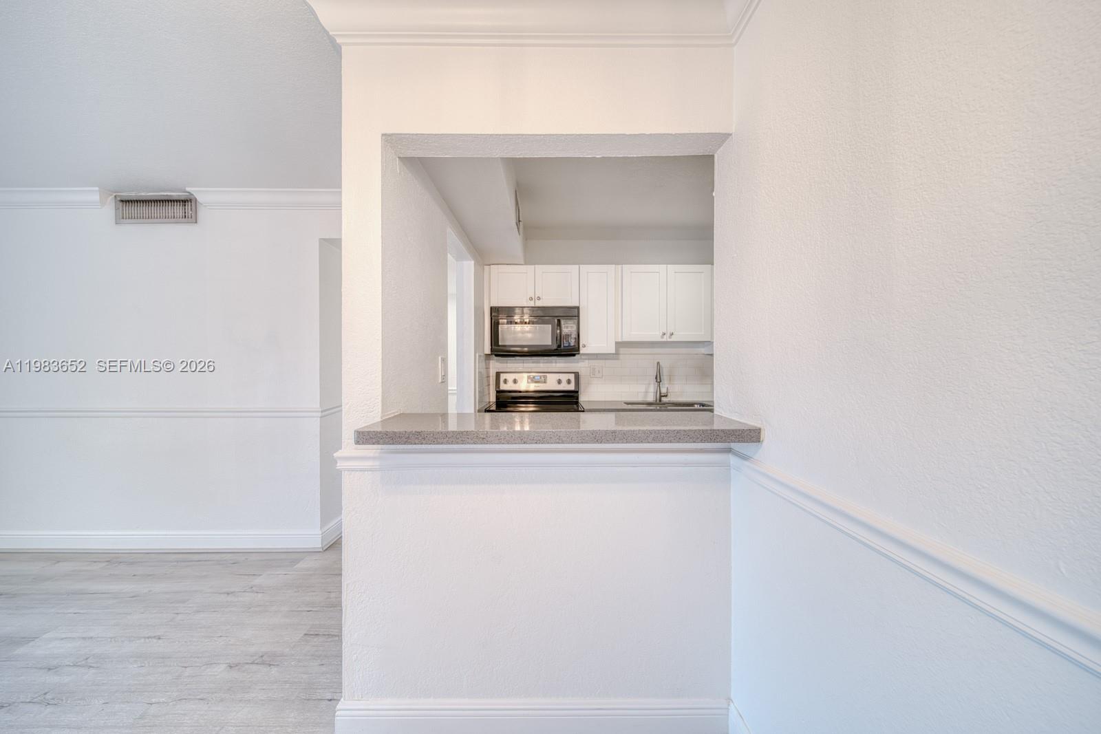 9459 Southwest 76th Street, Unit R5 Miami, FL 33173 - Photo 10 of 33 a kitchen with a sink and cabinets