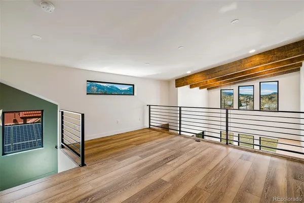 a view of a livingroom with wooden floor and stairs