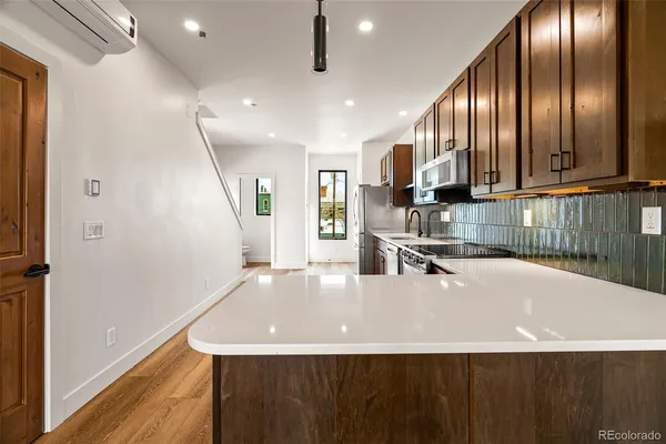 a view of a hallway with wooden floor and staircase
