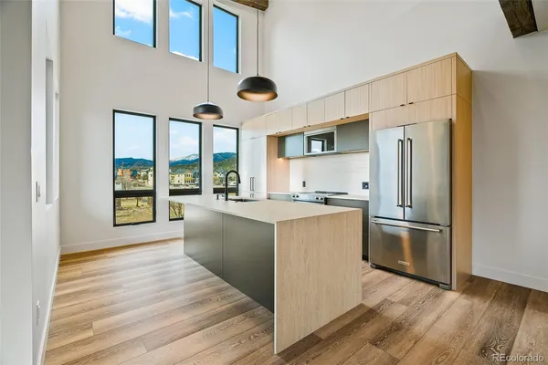 a kitchen with stainless steel appliances granite countertop a refrigerator a stove and a wooden floors