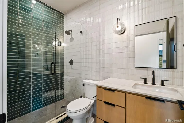 a bathroom with a granite countertop toilet sink and mirror