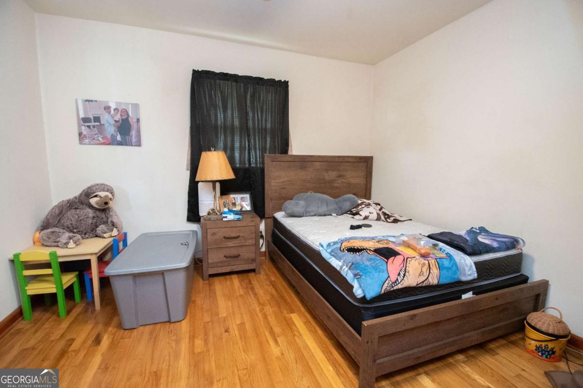 313 Mobley Street Griffin, GA 30223 - Photo 14 of 22 a bedroom with a bed and wooden floor