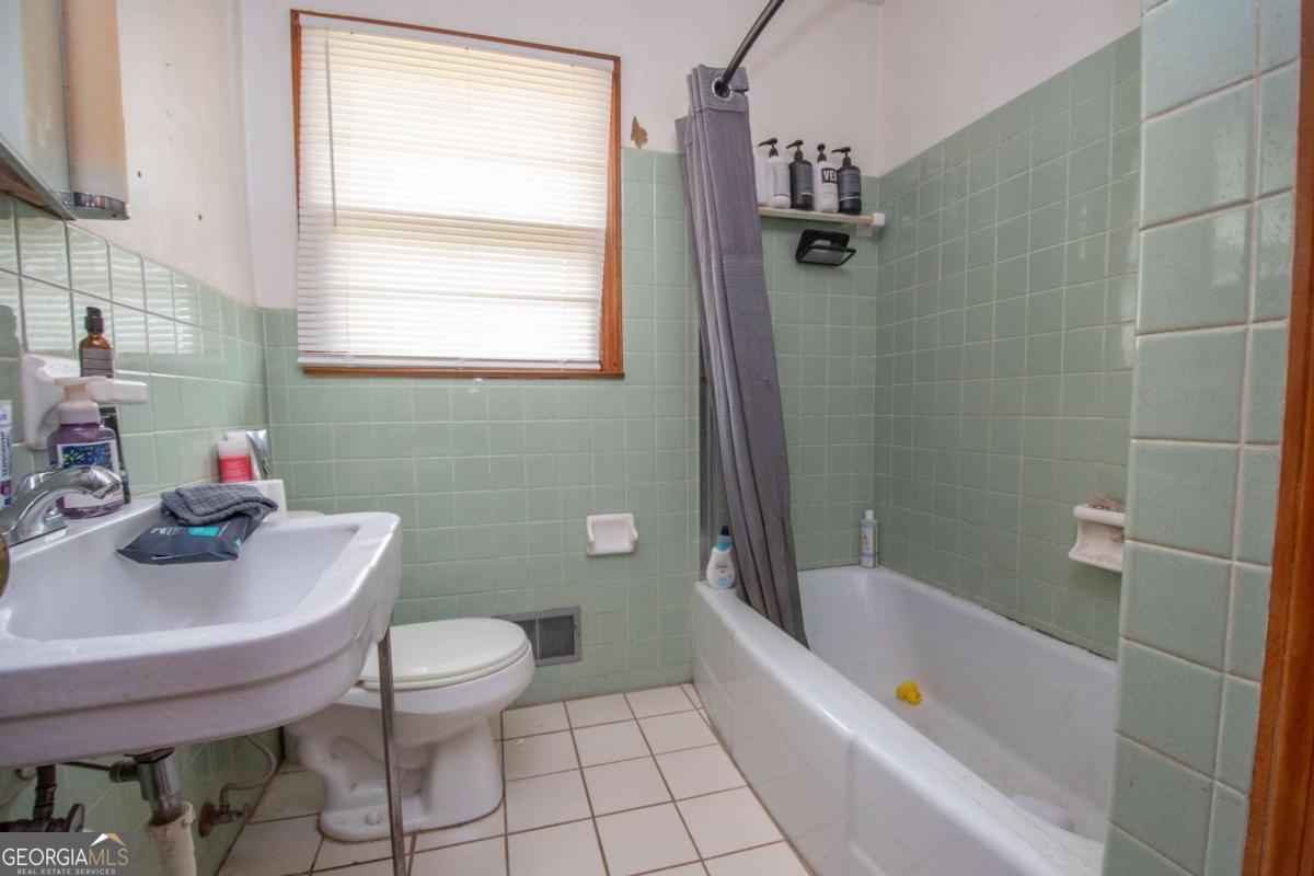 313 Mobley Street Griffin, GA 30223 - Photo 16 of 22 a bathroom with a sink a toilet and a bathtub