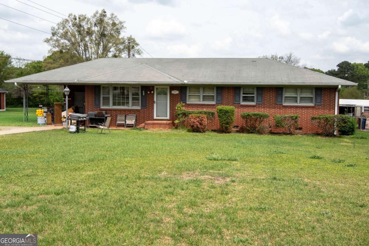 313 Mobley Street Griffin, GA 30223 - Photo 2 of 22 a front view of a house with a yard and trees