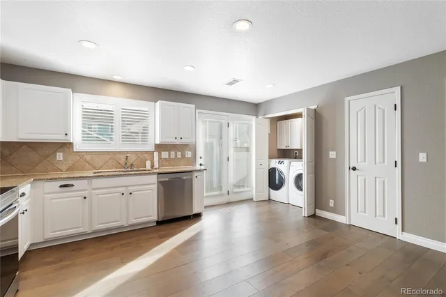 a large white kitchen with a large window