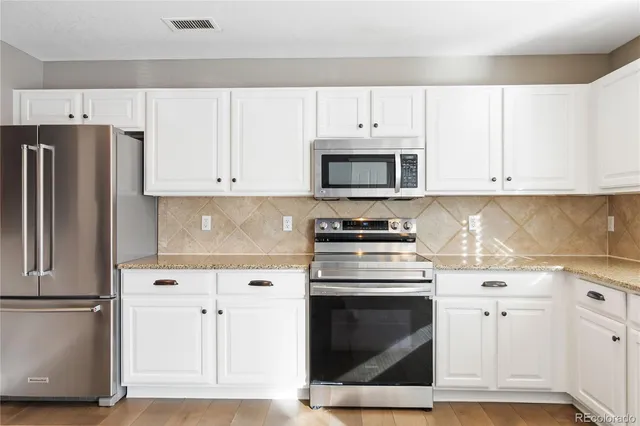a kitchen with cabinets stainless steel appliances and a sink