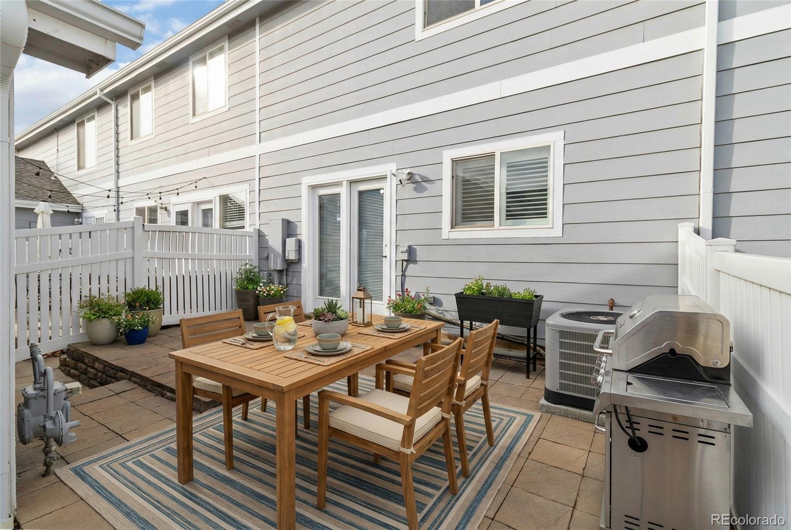 5796 Biscay Street Denver, CO 80249 - Photo 32 of 42 a view of a patio with table and chairs and potted plants