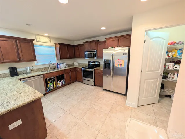 a kitchen with stainless steel appliances granite countertop a refrigerator sink and microwave