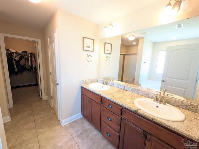 a spacious bathroom with a double vanity sink and a mirror
