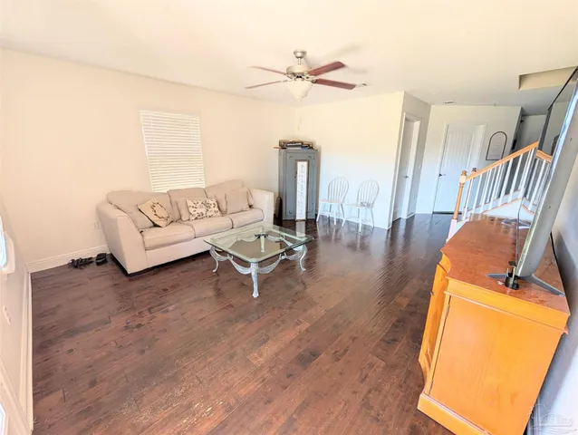 a living room with furniture and a wooden floor