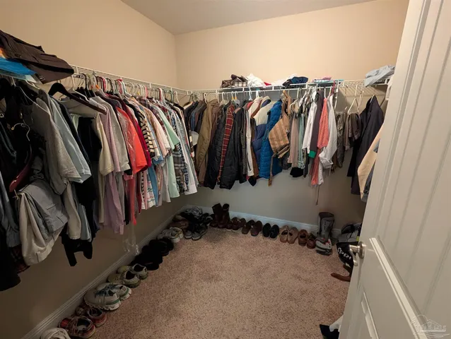 a view of walk in closet with clothes and shoes